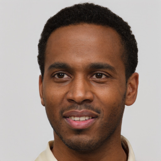 Joyful black young-adult male with short  brown hair and brown eyes