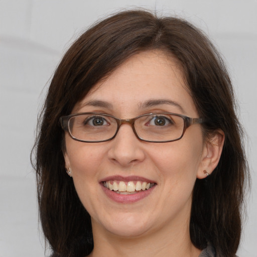 Joyful white adult female with medium  brown hair and brown eyes