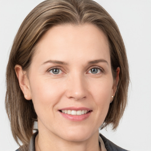 Joyful white adult female with medium  brown hair and grey eyes