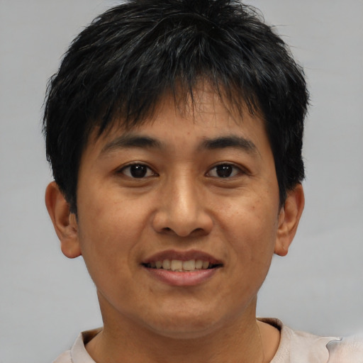 Joyful asian young-adult male with short  brown hair and brown eyes