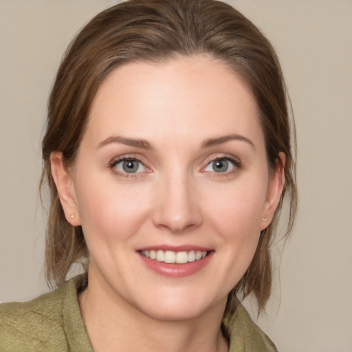 Joyful white young-adult female with medium  brown hair and grey eyes