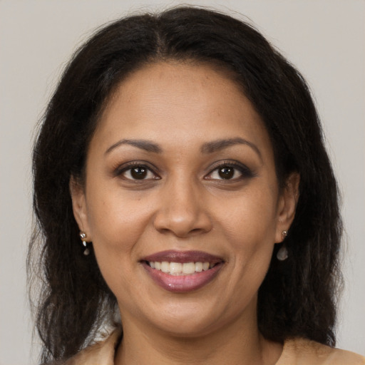 Joyful black adult female with long  brown hair and brown eyes