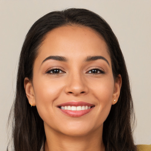 Joyful latino young-adult female with long  brown hair and brown eyes