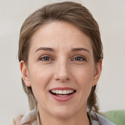 Joyful white young-adult female with medium  brown hair and grey eyes