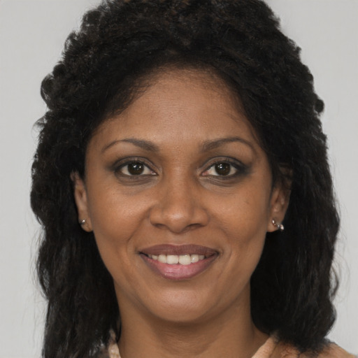 Joyful black adult female with long  brown hair and brown eyes