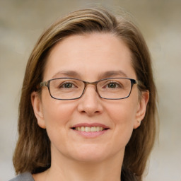 Joyful white adult female with medium  brown hair and blue eyes