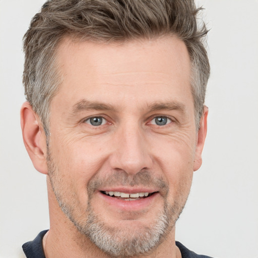 Joyful white adult male with short  brown hair and grey eyes