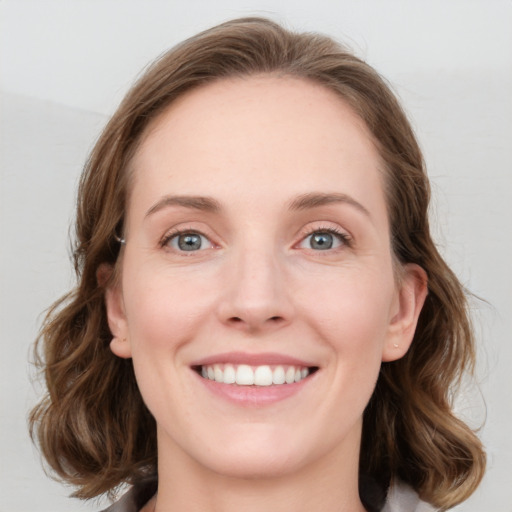 Joyful white young-adult female with medium  brown hair and blue eyes