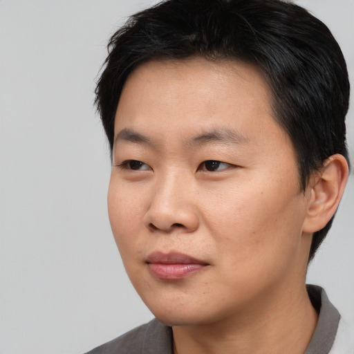 Joyful asian young-adult male with short  black hair and brown eyes