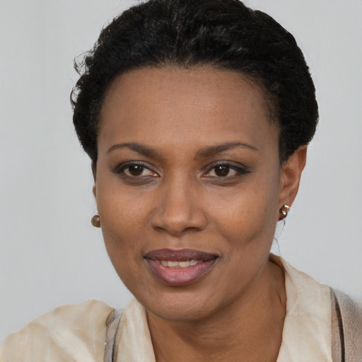 Joyful black young-adult female with short  black hair and brown eyes