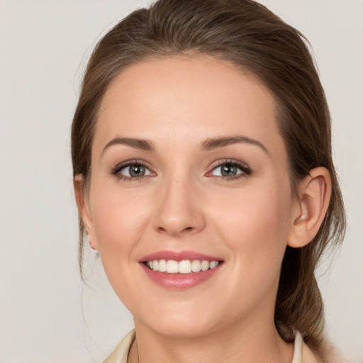 Joyful white young-adult female with medium  brown hair and grey eyes