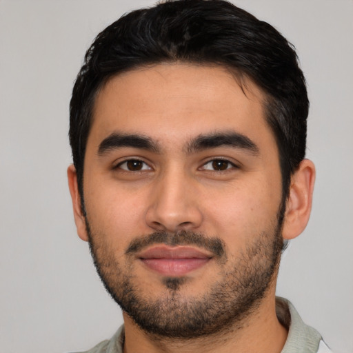 Joyful latino young-adult male with short  black hair and brown eyes