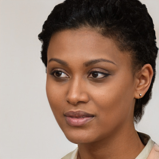 Joyful black young-adult female with short  black hair and brown eyes