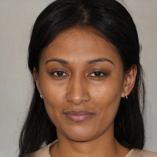 Joyful latino adult female with long  brown hair and brown eyes