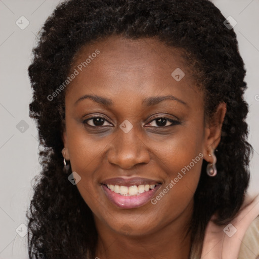 Joyful black young-adult female with long  brown hair and brown eyes