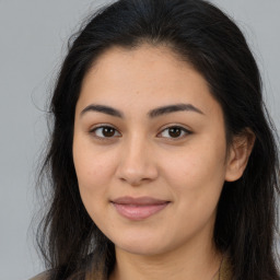 Joyful latino young-adult female with long  brown hair and brown eyes