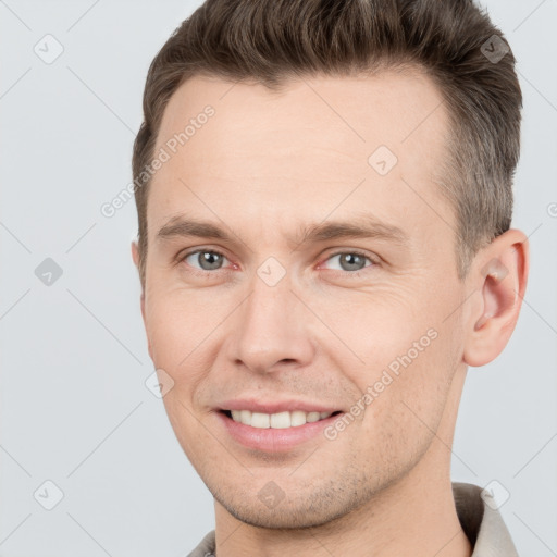 Joyful white adult male with short  brown hair and grey eyes