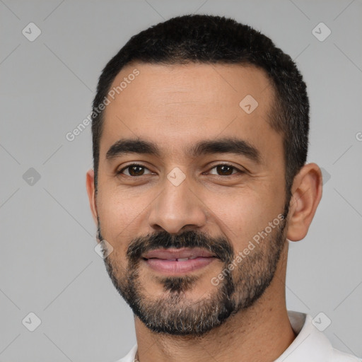 Joyful latino young-adult male with short  black hair and brown eyes