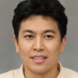 Joyful asian young-adult male with short  brown hair and brown eyes