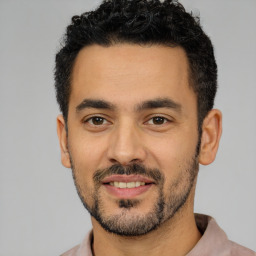 Joyful latino young-adult male with short  black hair and brown eyes