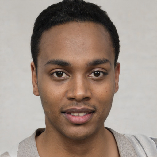 Joyful black young-adult male with short  black hair and brown eyes