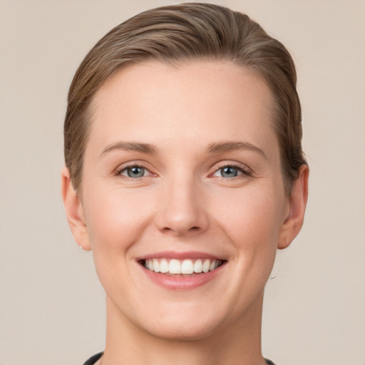 Joyful white young-adult female with short  brown hair and grey eyes