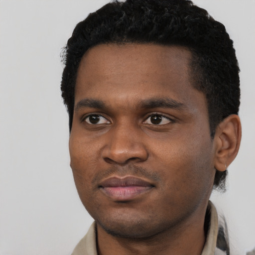 Joyful black young-adult male with short  black hair and brown eyes