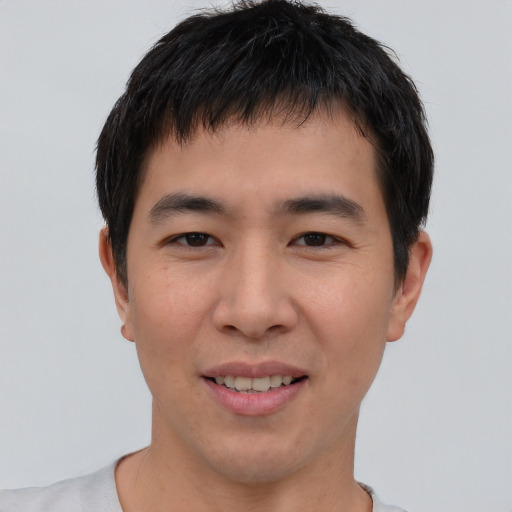 Joyful asian young-adult male with short  brown hair and brown eyes