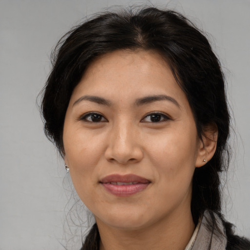 Joyful latino adult female with long  brown hair and brown eyes