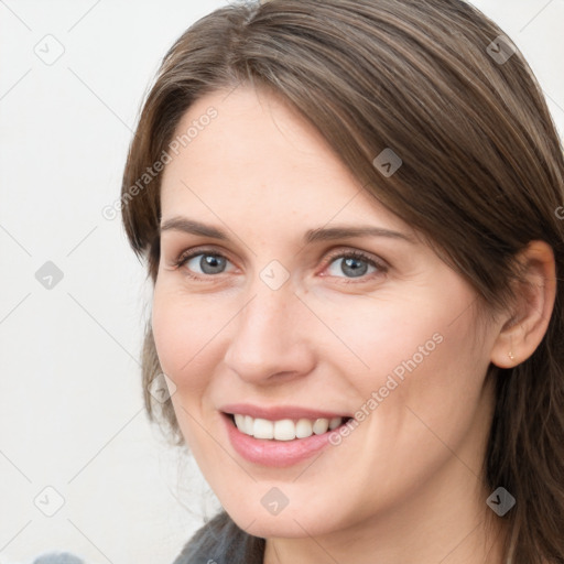 Joyful white young-adult female with medium  brown hair and grey eyes