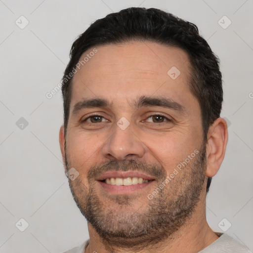 Joyful white young-adult male with short  black hair and brown eyes