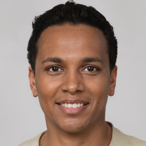 Joyful black young-adult male with short  black hair and brown eyes