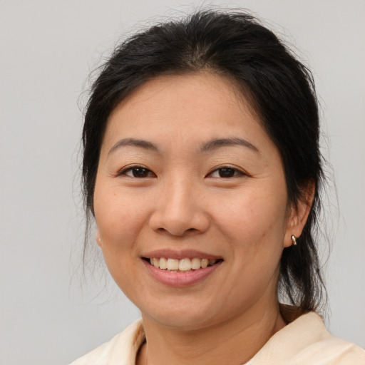 Joyful latino adult female with medium  brown hair and brown eyes