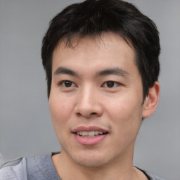 Joyful asian young-adult male with short  brown hair and brown eyes