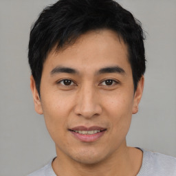 Joyful asian young-adult male with short  black hair and brown eyes