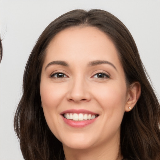 Joyful white young-adult female with long  brown hair and brown eyes