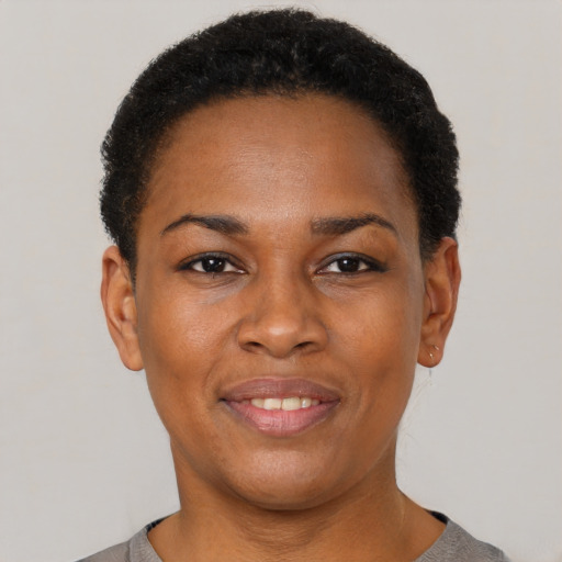 Joyful black young-adult female with short  black hair and brown eyes