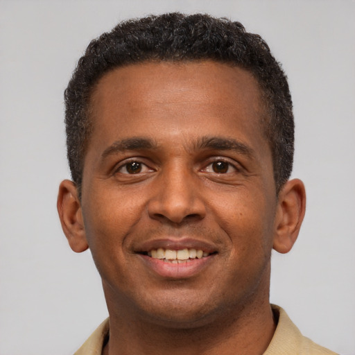 Joyful latino young-adult male with short  brown hair and brown eyes