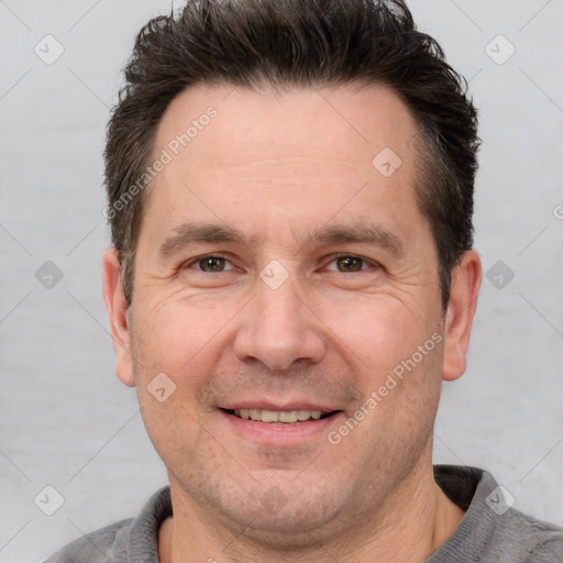 Joyful white adult male with short  brown hair and brown eyes