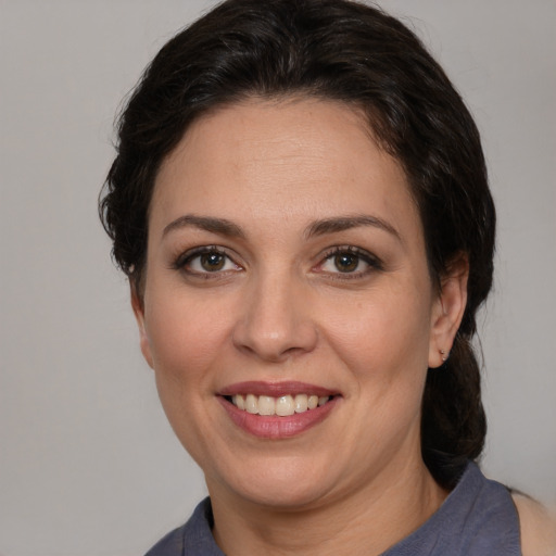 Joyful white adult female with medium  brown hair and brown eyes