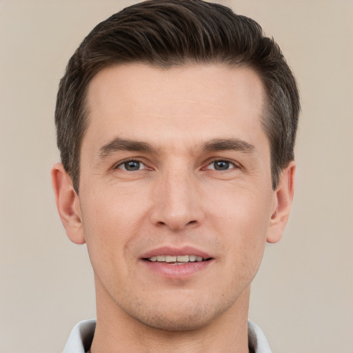 Joyful white young-adult male with short  brown hair and grey eyes