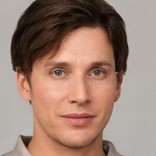 Joyful white young-adult male with short  brown hair and grey eyes