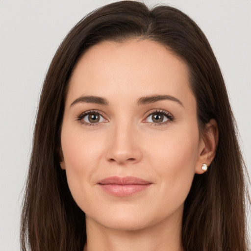 Joyful white young-adult female with long  brown hair and brown eyes