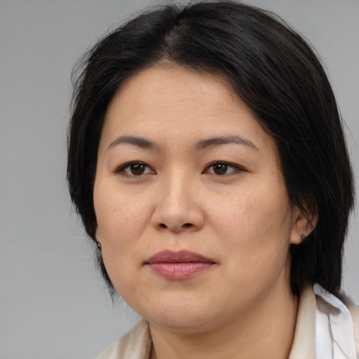 Joyful asian adult female with medium  brown hair and brown eyes