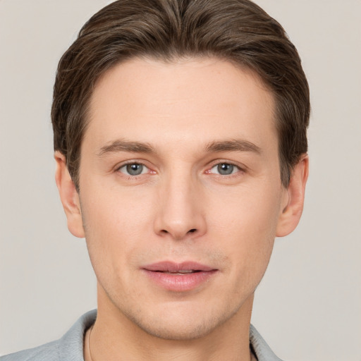 Joyful white young-adult male with short  brown hair and grey eyes