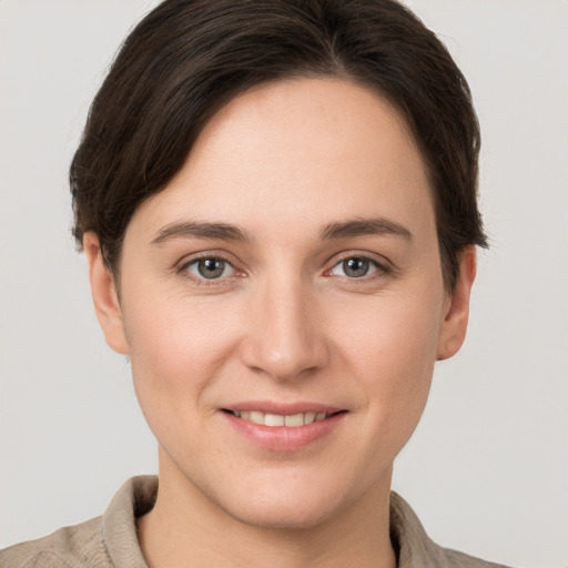 Joyful white young-adult female with short  brown hair and grey eyes