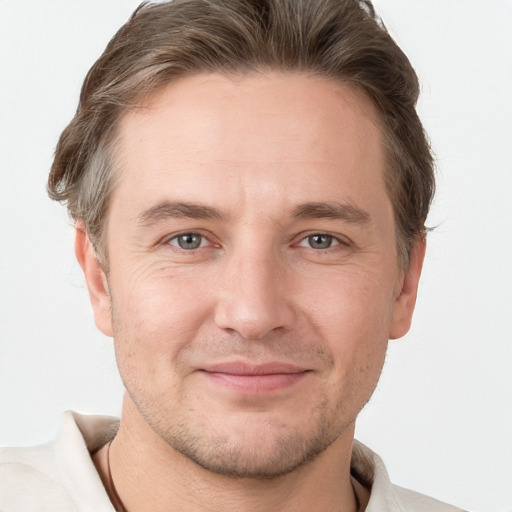 Joyful white adult male with short  brown hair and grey eyes