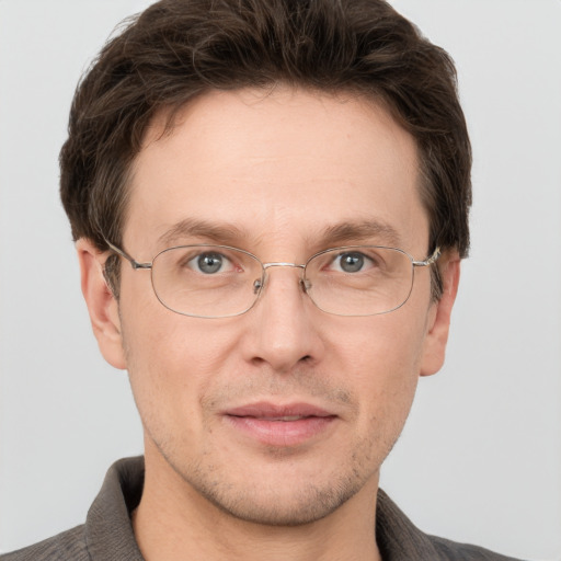 Joyful white adult male with short  brown hair and grey eyes