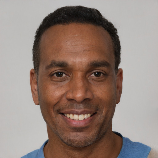 Joyful black adult male with short  brown hair and brown eyes