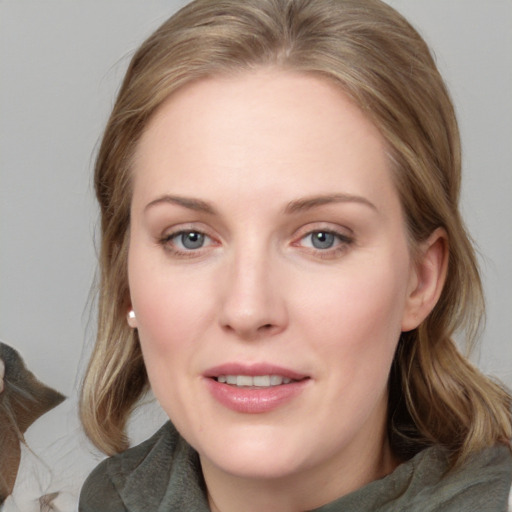 Joyful white young-adult female with medium  brown hair and blue eyes